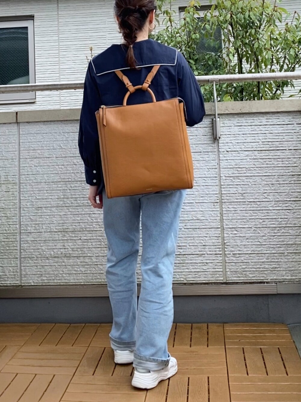 ブルー系のシャツ/ブラウス、ブルー系のデニムパンツ、イエロー系のバックパック/リュックを着用したレディースの春コーディネートの3枚目の写真