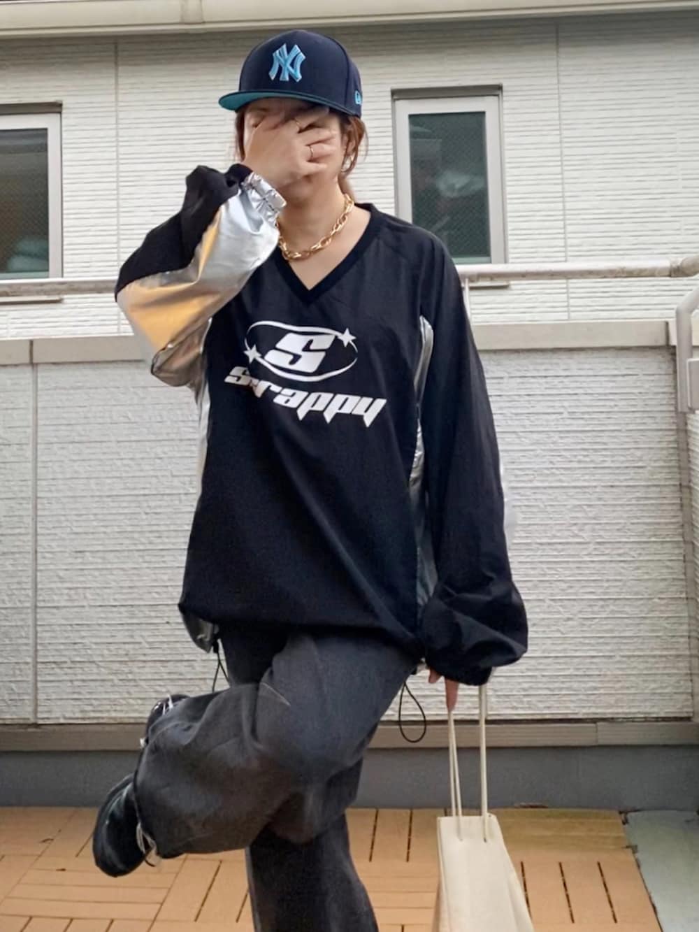 ブラック系のトップス、ブラック系のデニムパンツ、ブラック系のスニーカーを着用したレディースの秋コーディネートの5枚目の写真