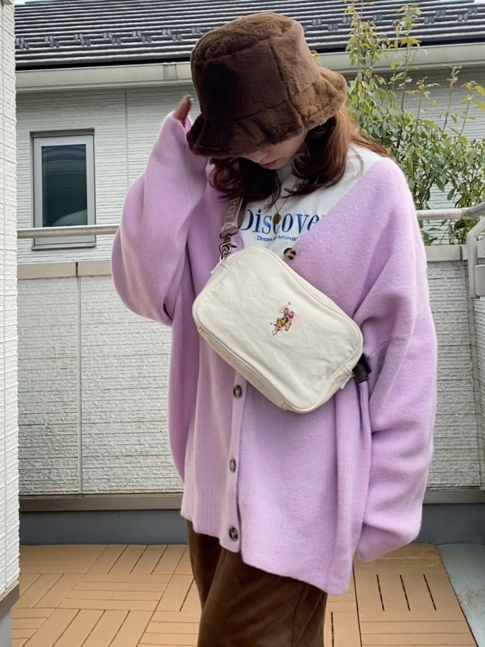 パープル系のカーディガン/ボレロ、ホワイト系のTシャツ/カットソー、ブラウン系のスカートを着用したレディースの冬コーディネートの2枚目の写真