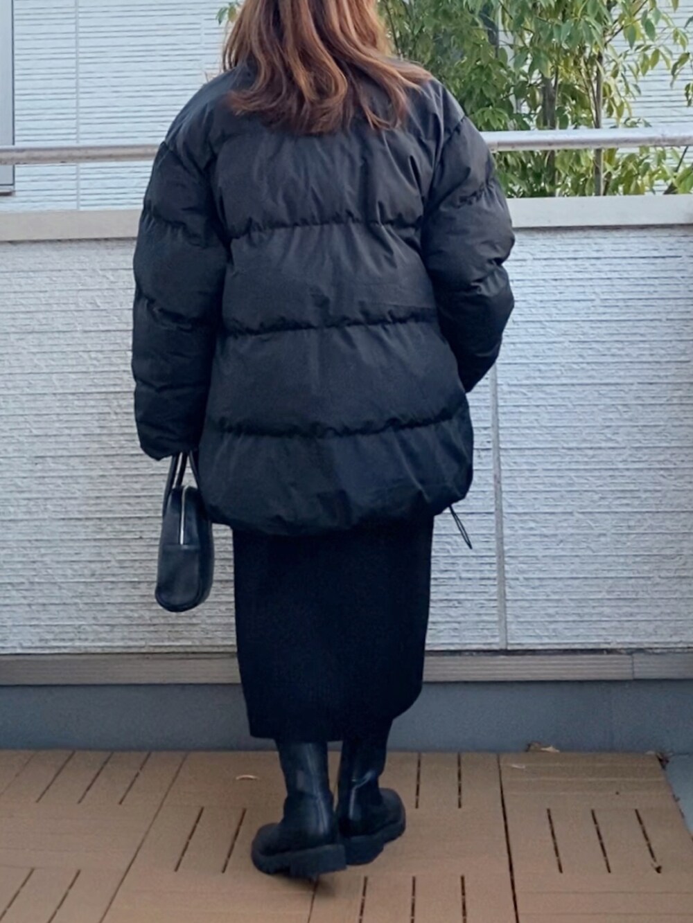 ブラック系のダウンジャケット/コート、ブラック系のワンピース、ブラック系のショルダーバッグを着用したレディースの冬コーディネートの3枚目の写真