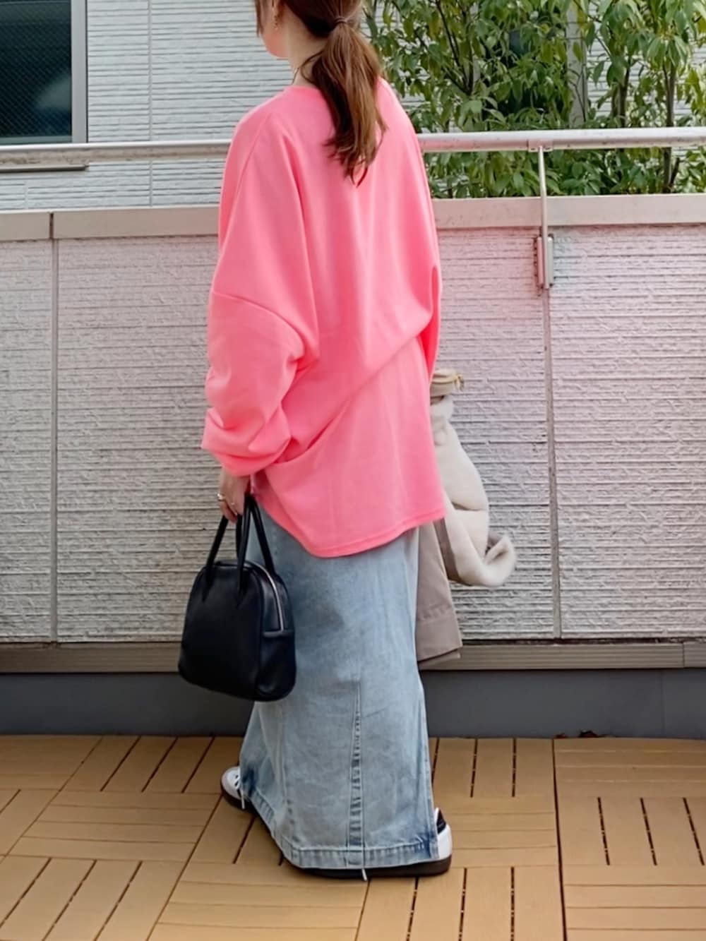 ピンク系のTシャツ/カットソー、ベージュ系のマウンテンパーカー、ブルー系のデニムスカートを着用したレディースの冬コーディネートの5枚目の写真