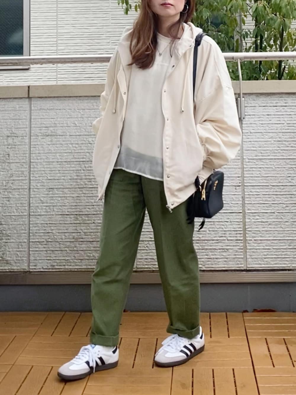 ホワイト系のマウンテンパーカー、ホワイト系のスウェット、グリーン系のその他パンツを着用したレディースの春コーディネートの2枚目の写真
