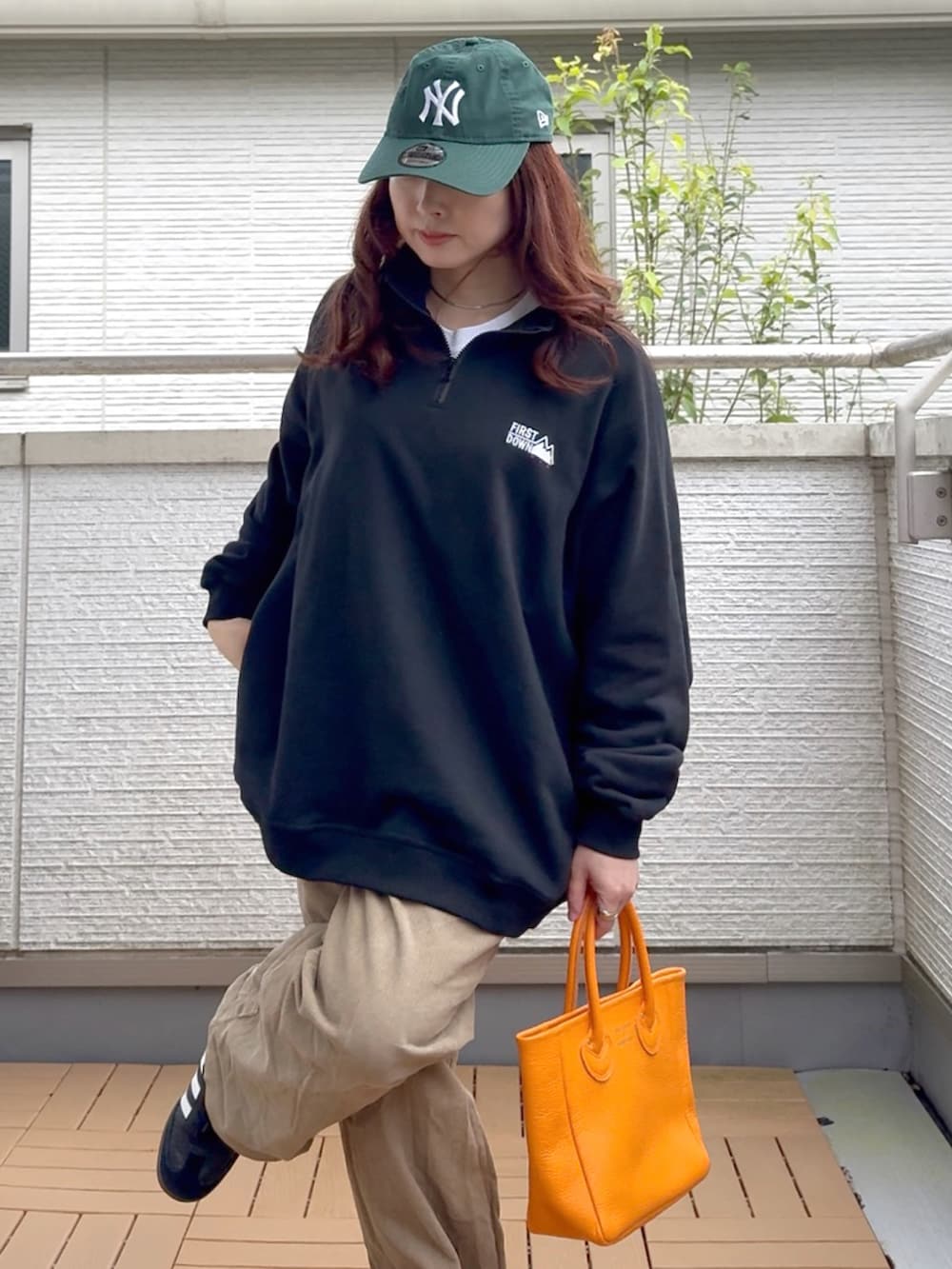 ブラック系のスウェット、オレンジ系のトートバッグ、ブラック系のスニーカーを着用したレディースの秋コーディネートの5枚目の写真