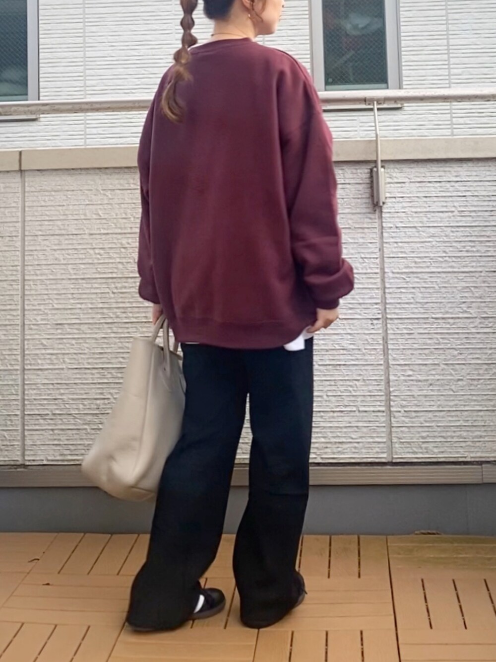 レッド系のスウェット、ブラック系のその他パンツ、ベージュ系のトートバッグを着用したレディースの秋コーディネートの4枚目の写真