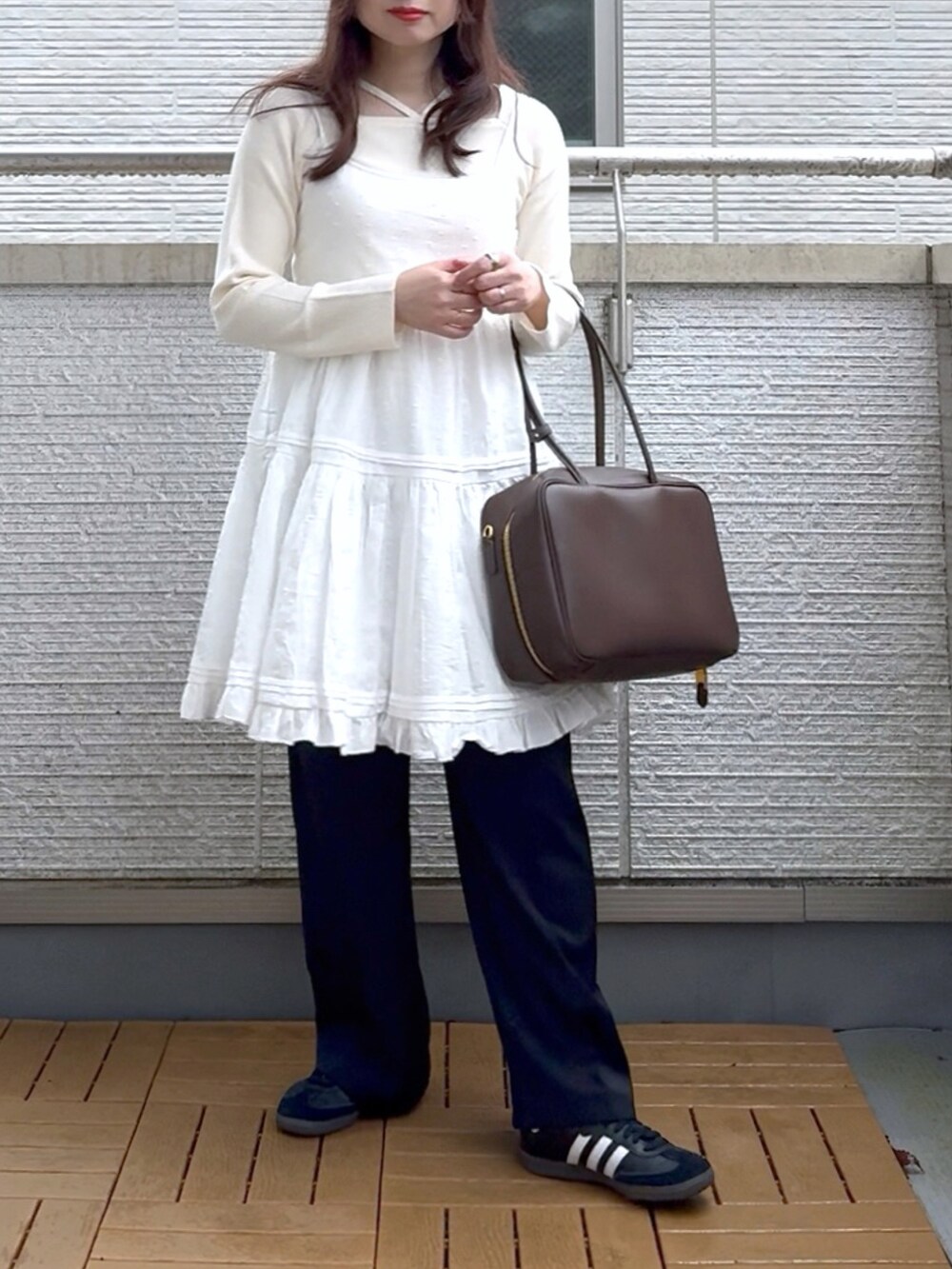 ホワイト系のワンピース、ホワイト系のTシャツ/カットソー、ブラック系のスラックスを着用したレディースの春コーディネートの2枚目の写真