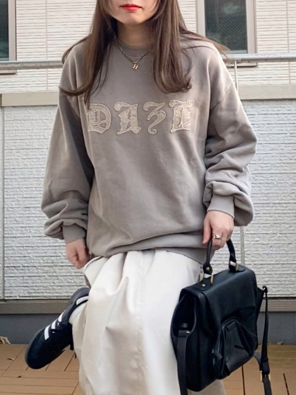 ベージュ系のトップス、ホワイト系のスカート、ブラック系のハンドバッグを着用したレディースの冬コーディネートの4枚目の写真