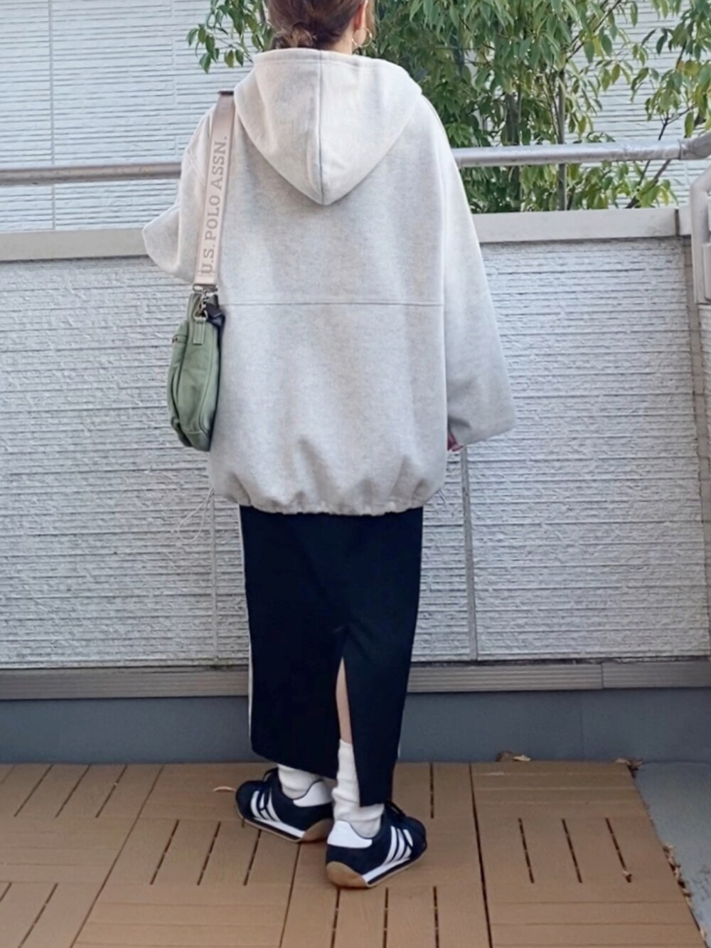 ホワイト系のパーカー、ホワイト系のTシャツ/カットソー、ブラック系のスカートを着用したレディースの冬コーディネートの3枚目の写真