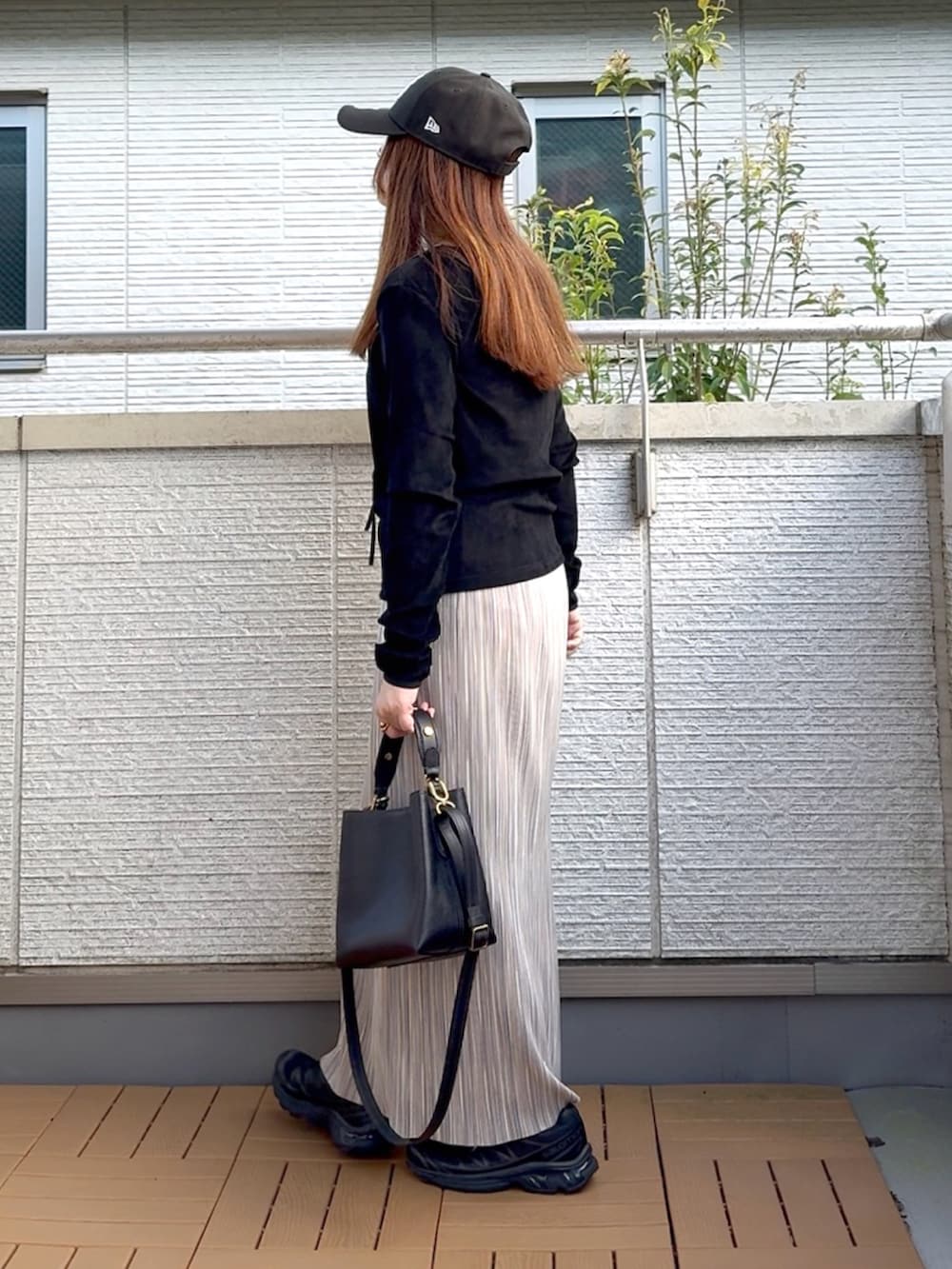 ブラック系のTシャツ/カットソー、グレー系のスカート、ブラック系のショルダーバッグを着用したレディースの秋コーディネートの4枚目の写真