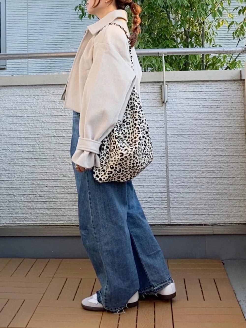 ホワイト系のブルゾン、イエロー系のニット/セーター、ホワイト系のトートバッグを着用したレディースの秋コーディネートの2枚目の写真