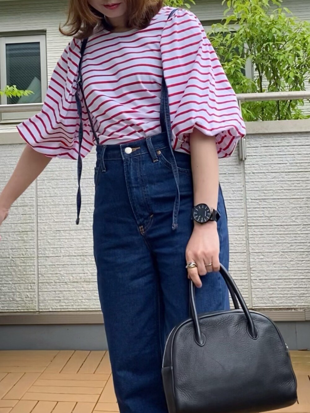 レッド系のTシャツ/カットソー、ブルー系のデニムパンツ、ブラック系のショルダーバッグを着用したレディースの夏コーディネートの2枚目の写真