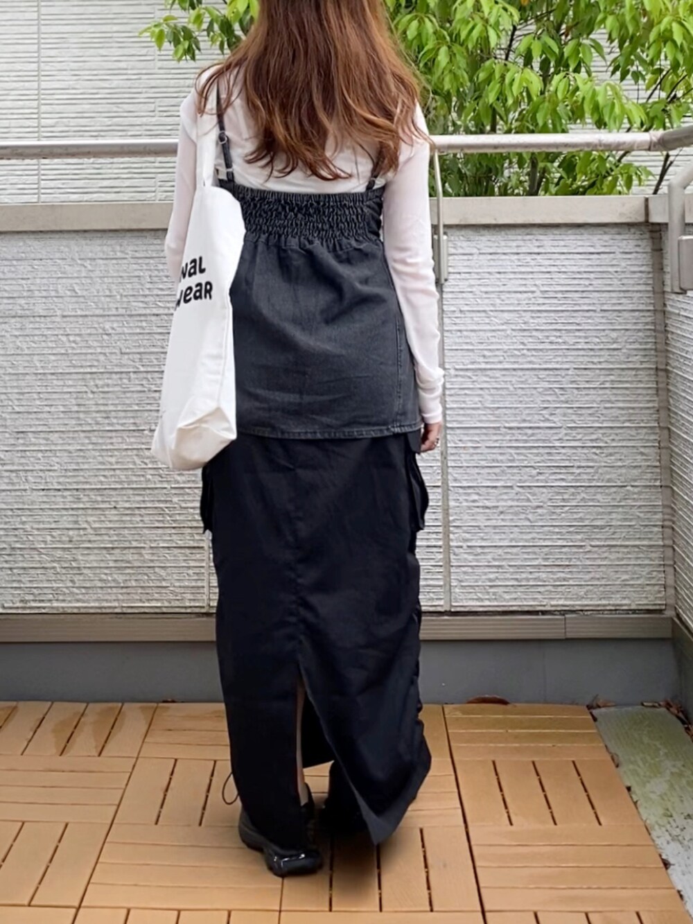 ホワイト系のTシャツ/カットソー、ブラック系のベスト、ブラック系のスカートを着用したレディースの春コーディネートの4枚目の写真