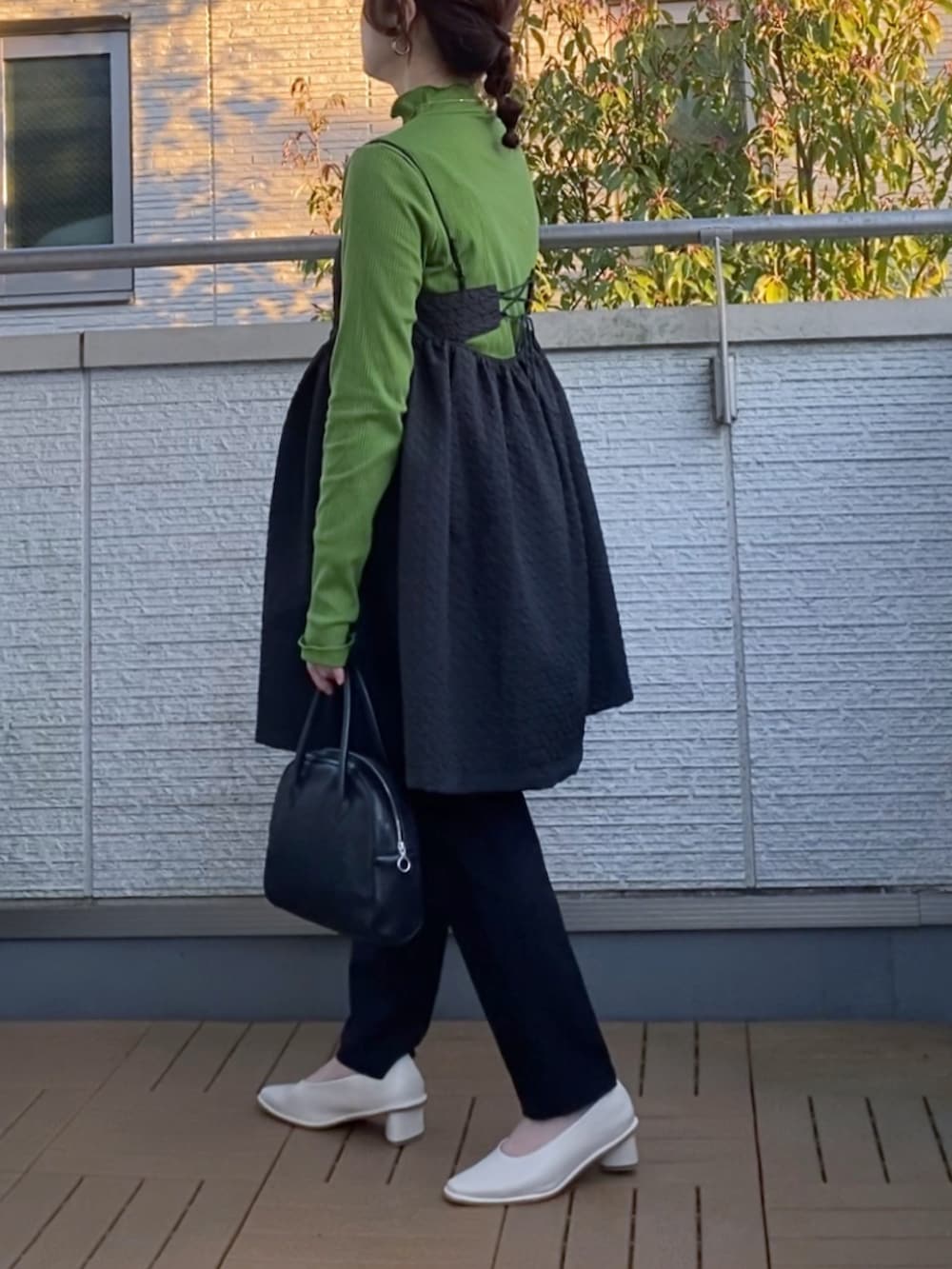 ブラック系のワンピース、グリーン系のTシャツ/カットソー、ブラック系のその他パンツを着用したレディースの春コーディネートの2枚目の写真