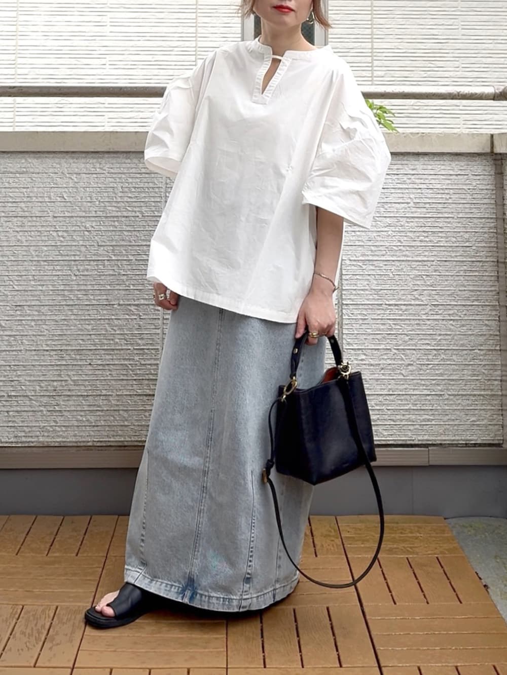 ホワイト系のシャツ/ブラウス、ブルー系のデニムスカート、ブラック系のショルダーバッグを着用したレディースの夏コーディネートの2枚目の写真