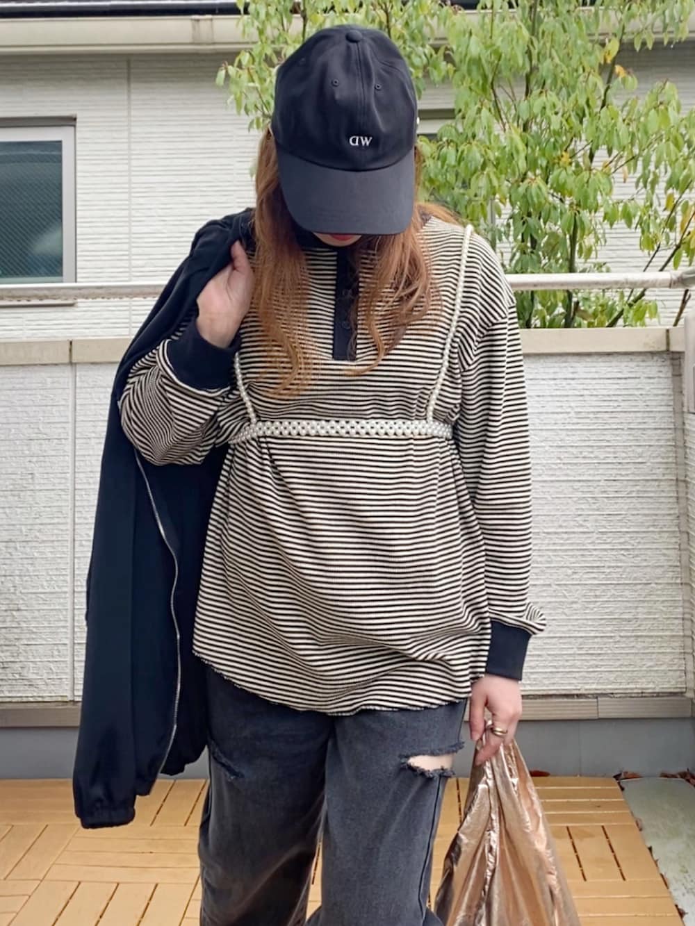 ホワイト系のTシャツ/カットソー、ブラック系のブルゾン、ブラック系のデニムパンツを着用したレディースの春コーディネートの3枚目の写真