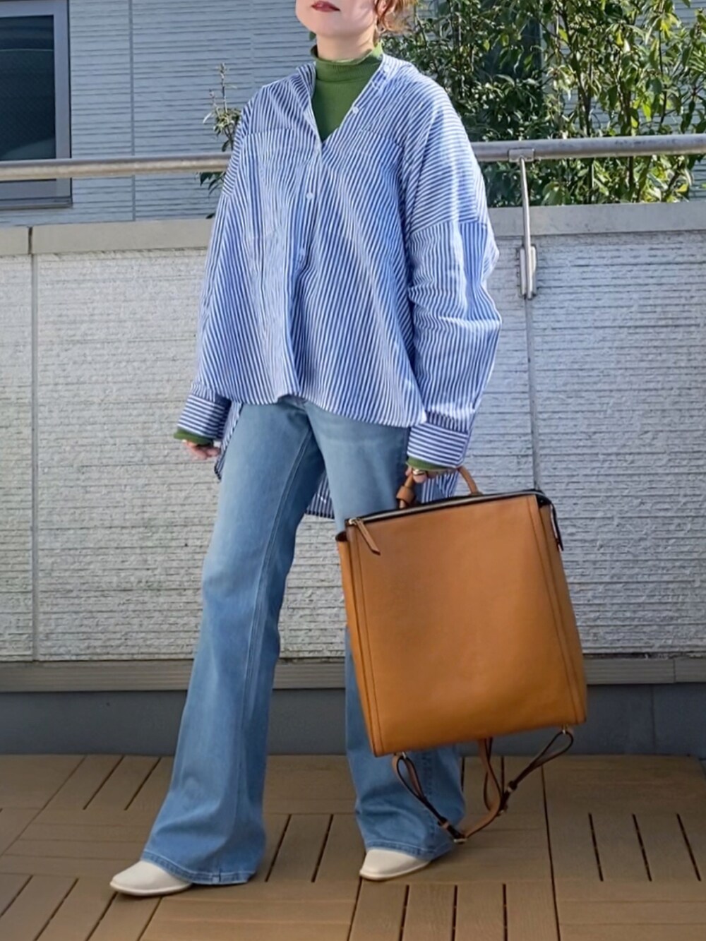 ブルー系のシャツ/ブラウス、グリーン系のTシャツ/カットソー、ブルー系のデニムパンツを着用したレディースの春コーディネートの2枚目の写真