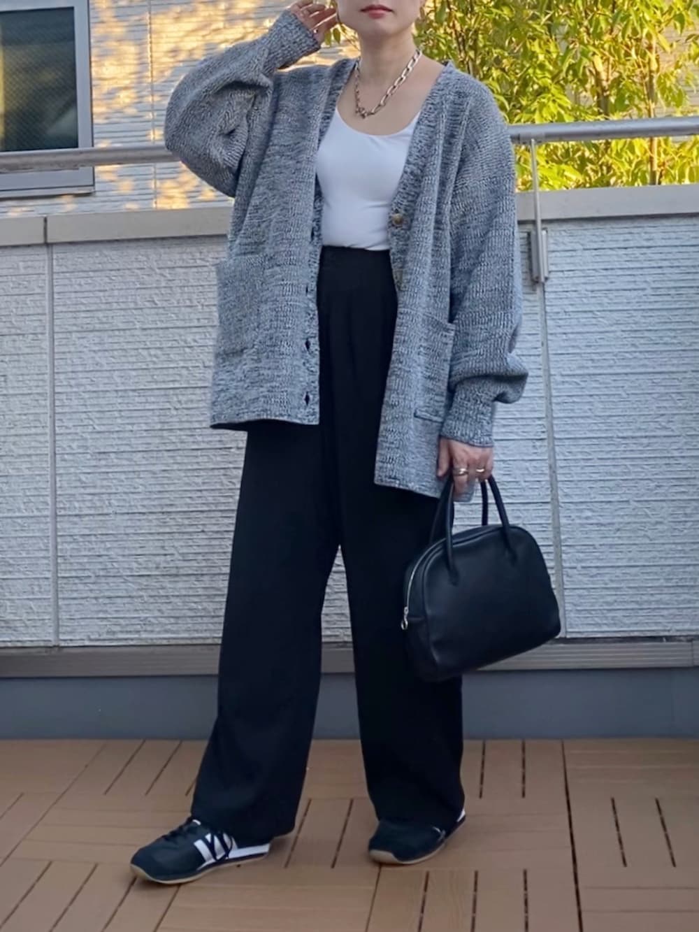 グレー系のカーディガン/ボレロ、ブラック系のショルダーバッグ、ブラック系のスニーカーを着用したレディースの秋コーディネートの2枚目の写真