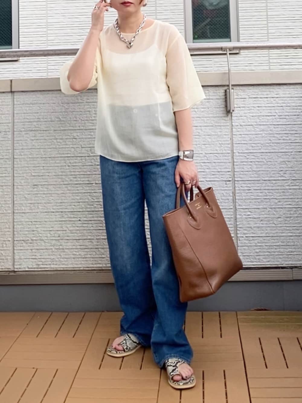 ホワイト系のシャツ/ブラウス、ブルー系のデニムパンツ、ブラウン系のトートバッグを着用したレディースの夏コーディネートの2枚目の写真
