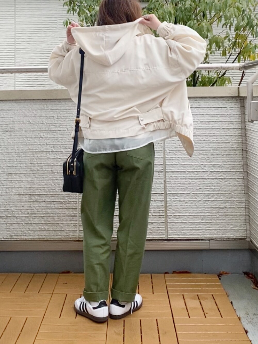 ホワイト系のマウンテンパーカー、ホワイト系のスウェット、グリーン系のその他パンツを着用したレディースの春コーディネートの3枚目の写真