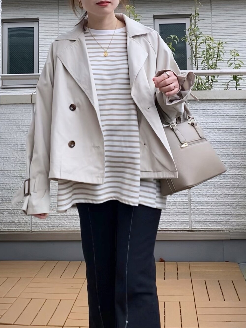 ホワイト系のトレンチコート、ベージュ系のTシャツ/カットソー、ブラック系のデニムパンツを着用したレディースの春コーディネートの4枚目の写真