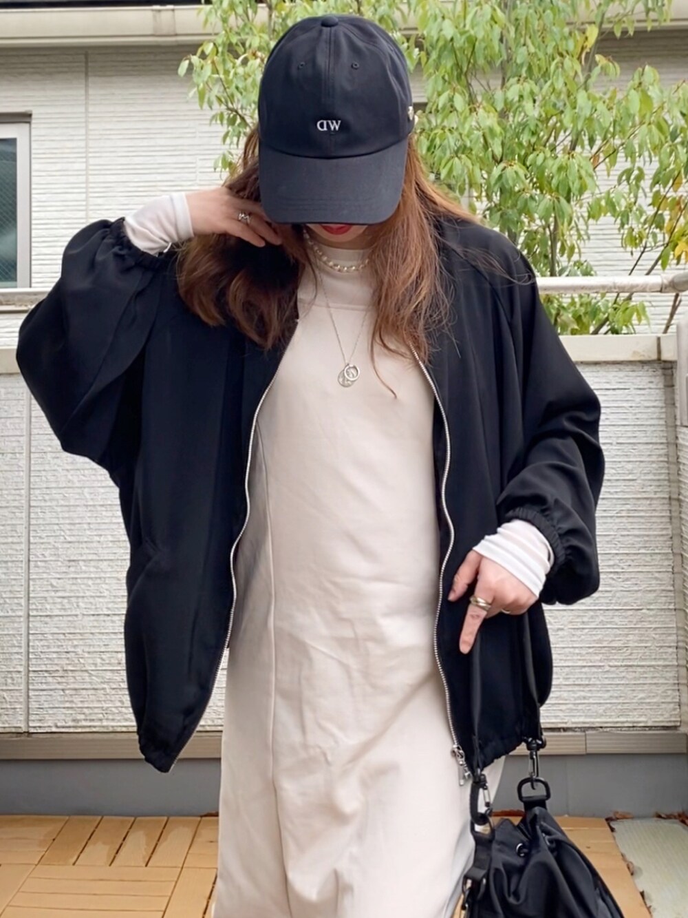 ブラック系のブルゾン、ホワイト系のワンピース、ホワイト系のTシャツ/カットソーを着用したレディースの春コーディネートの4枚目の写真