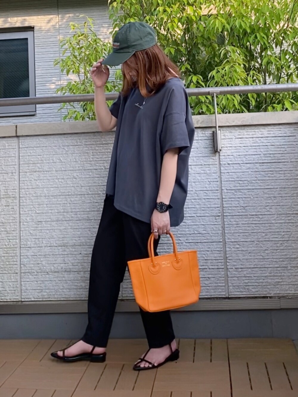 グレー系のTシャツ/カットソー、ブラック系のその他パンツ、オレンジ系のトートバッグを着用したレディースの春コーディネートの2枚目の写真