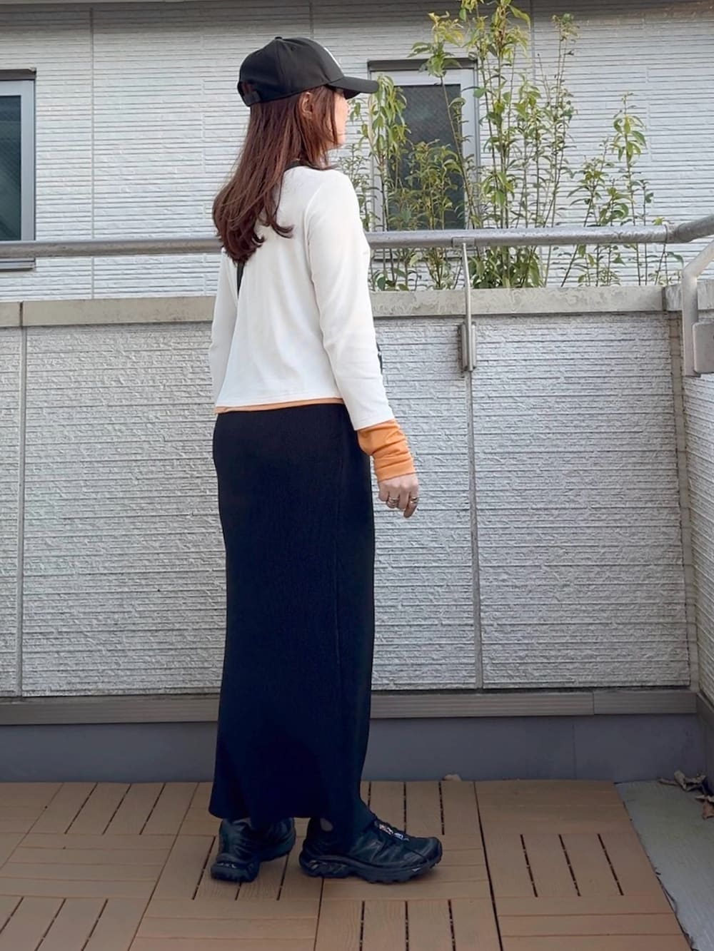 ブラック系のスカート、ホワイト系のTシャツ/カットソー、ブラック系のショルダーバッグを着用したレディースの春コーディネートの3枚目の写真