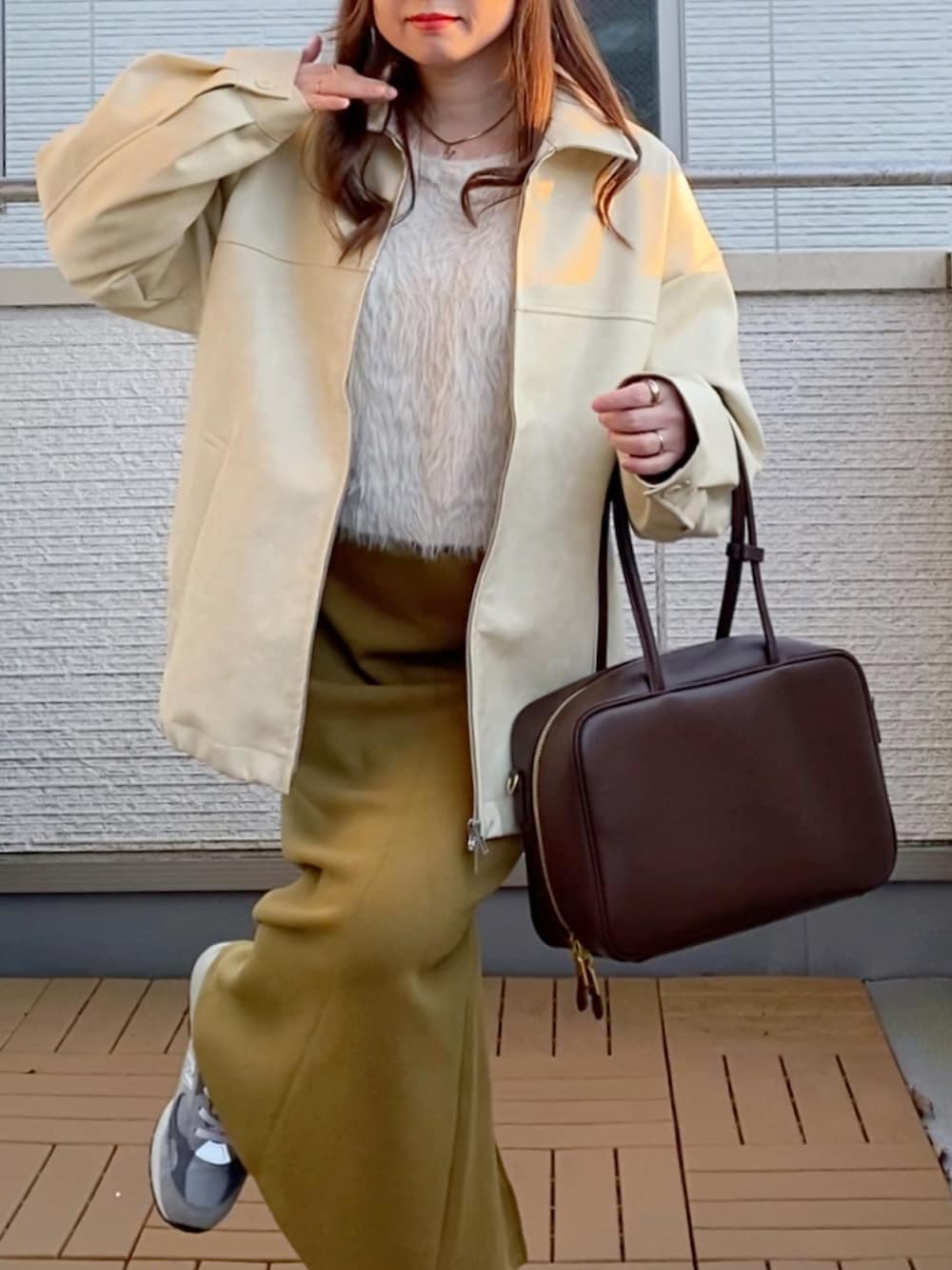 ホワイト系のブルゾン、ホワイト系のニット/セーター、グリーン系のスカートを着用したレディースの冬コーディネートの5枚目の写真