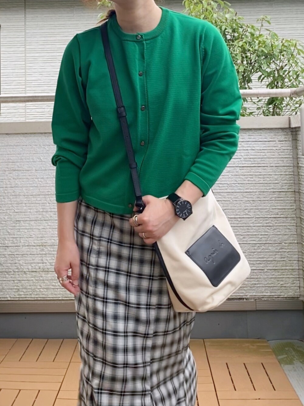 グリーン系のカーディガン/ボレロ、ブラック系のスカート、ホワイト系のショルダーバッグを着用したレディースの夏コーディネートの2枚目の写真