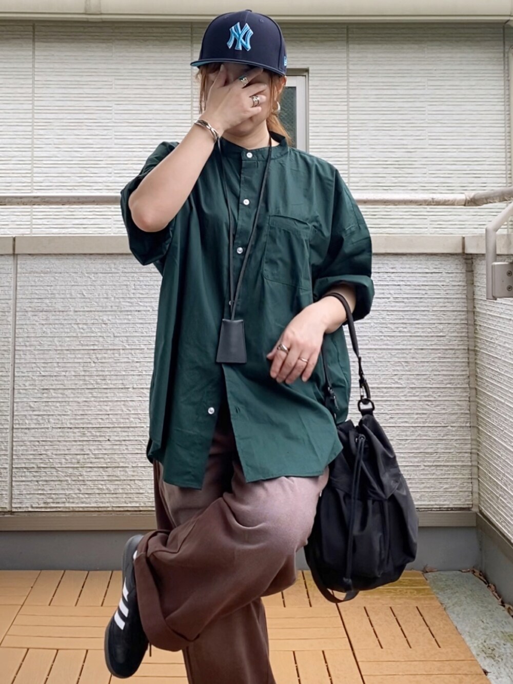 グリーン系のシャツ/ブラウス、ブラウン系のデニムパンツ、ブラック系のショルダーバッグを着用したレディースの夏コーディネートの4枚目の写真