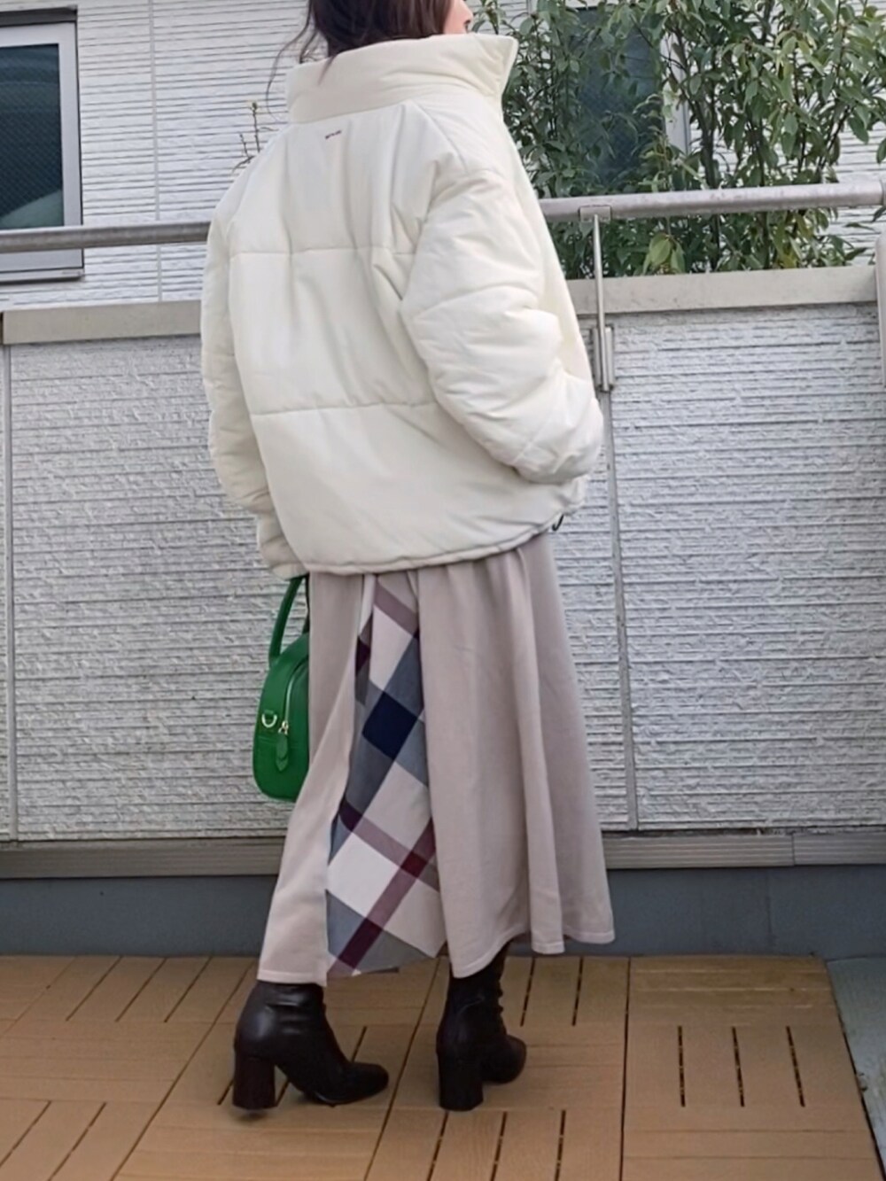 ベージュ系のダウンジャケット/コート、ベージュ系のワンピース、グリーン系のハンドバッグを着用したレディースの冬コーディネートの2枚目の写真