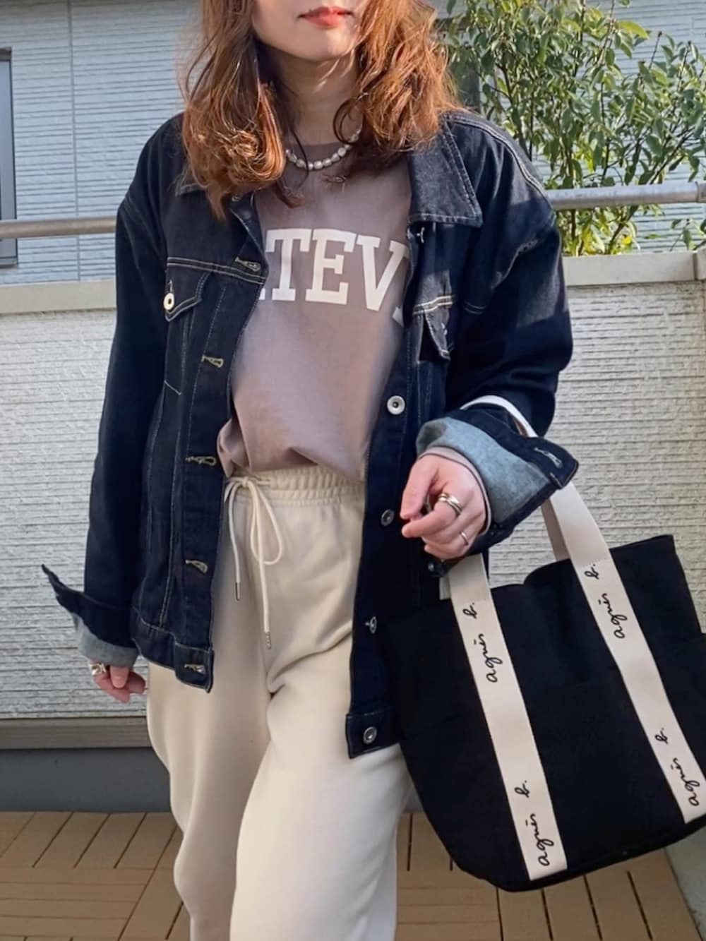 ブラウン系のTシャツ/カットソー、ブルー系のデニムジャケット、ホワイト系のパンツを着用したレディースの春コーディネートの2枚目の写真