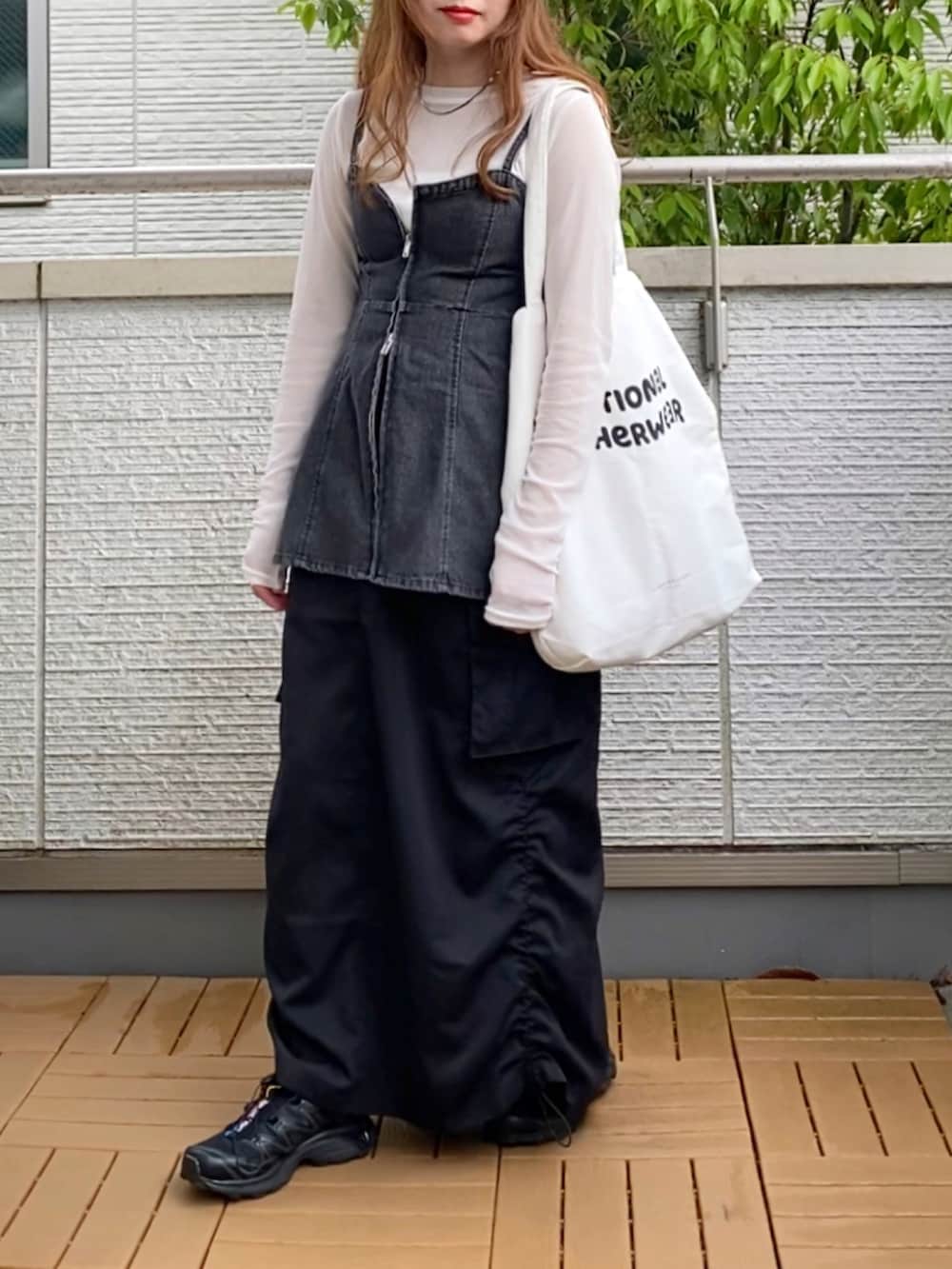 ホワイト系のTシャツ/カットソー、ブラック系のベスト、ブラック系のスカートを着用したレディースの春コーディネートの2枚目の写真