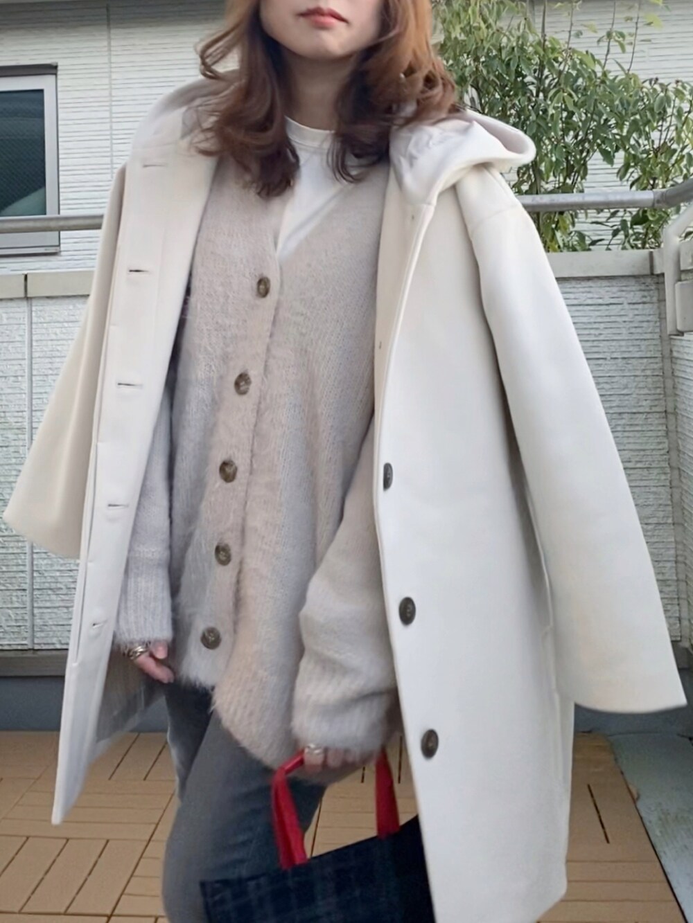 ホワイト系のその他アウター、グレー系のカーディガン/ボレロ、グレー系のデニムパンツを着用したレディースの冬コーディネートの4枚目の写真