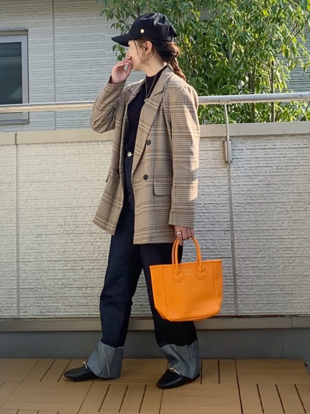 ブラウン系のテーラードジャケット、ブラック系のニット/セーター、ブルー系のデニムパンツを着用したレディースの秋コーディネートの2枚目の写真