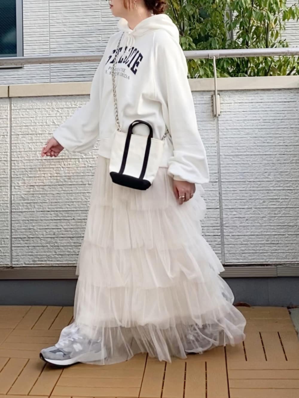 ホワイト系のパーカー、ホワイト系のスカート、グレー系のスニーカーを着用したレディースの春コーディネートの3枚目の写真