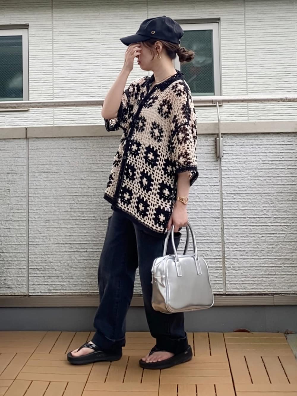 ブラック系のカーディガン/ボレロ、ブラック系のデニムパンツ、シルバー系のボストンバッグを着用したレディースの夏コーディネートの2枚目の写真