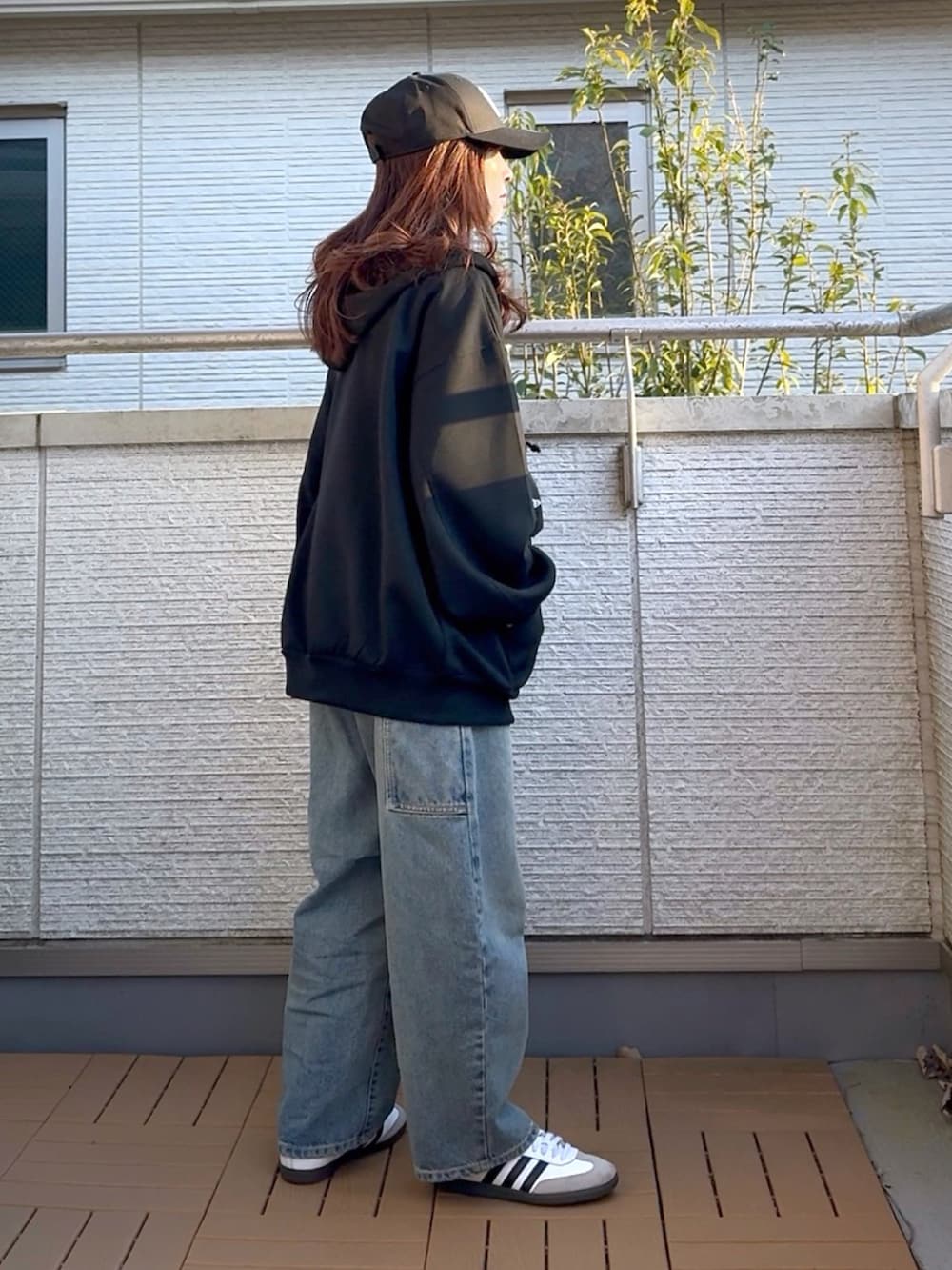 ブラック系のパーカー、ホワイト系のTシャツ/カットソー、ブラック系のショルダーバッグを着用したレディースの春コーディネートの3枚目の写真