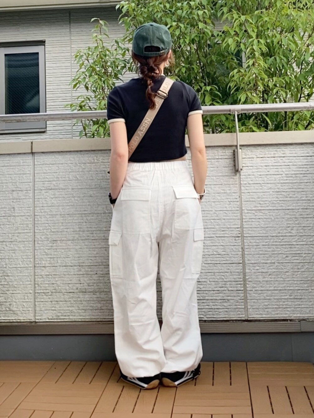 ブラック系のTシャツ/カットソー、ホワイト系のカーゴパンツ、グリーン系のショルダーバッグを着用したレディースの夏コーディネートの2枚目の写真