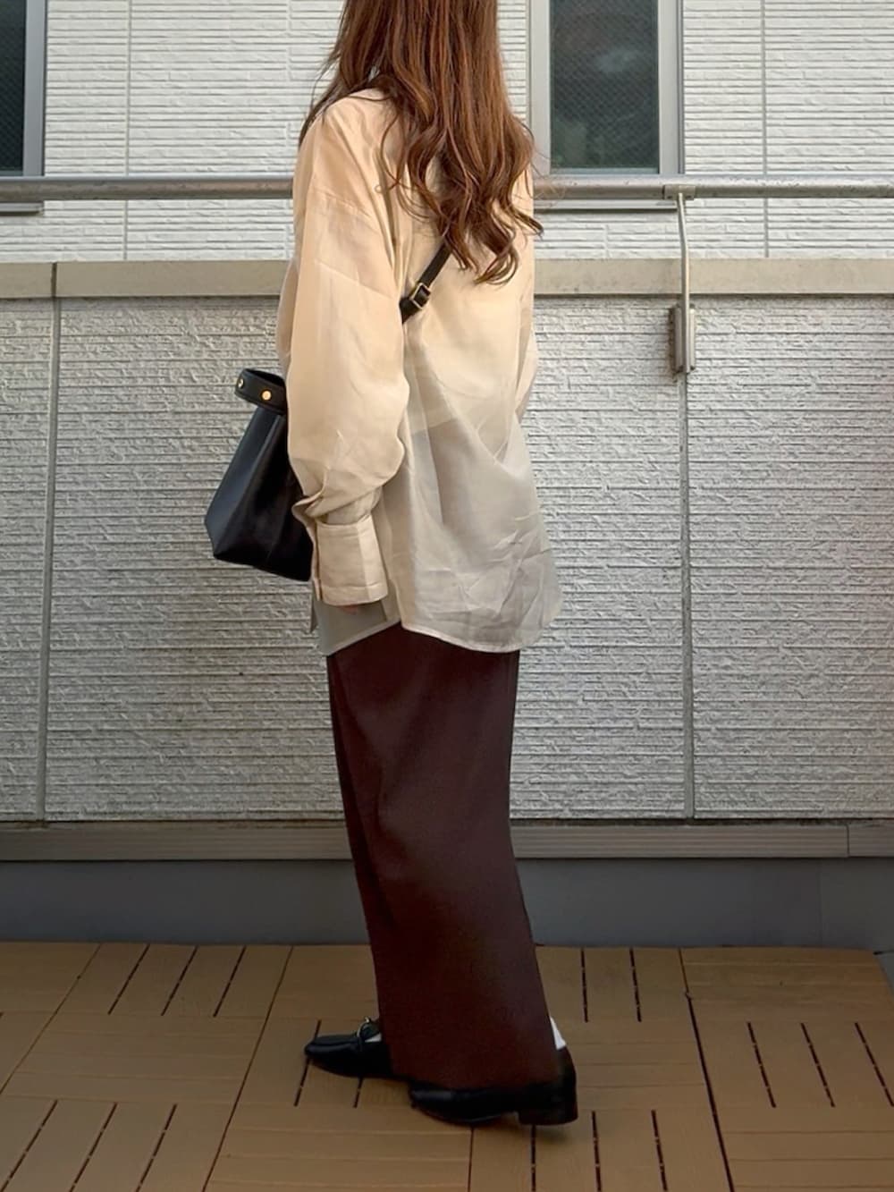 ベージュ系のシャツ/ブラウス、ブラウン系のスカート、ブラック系のショルダーバッグを着用したレディースの春コーディネートの3枚目の写真