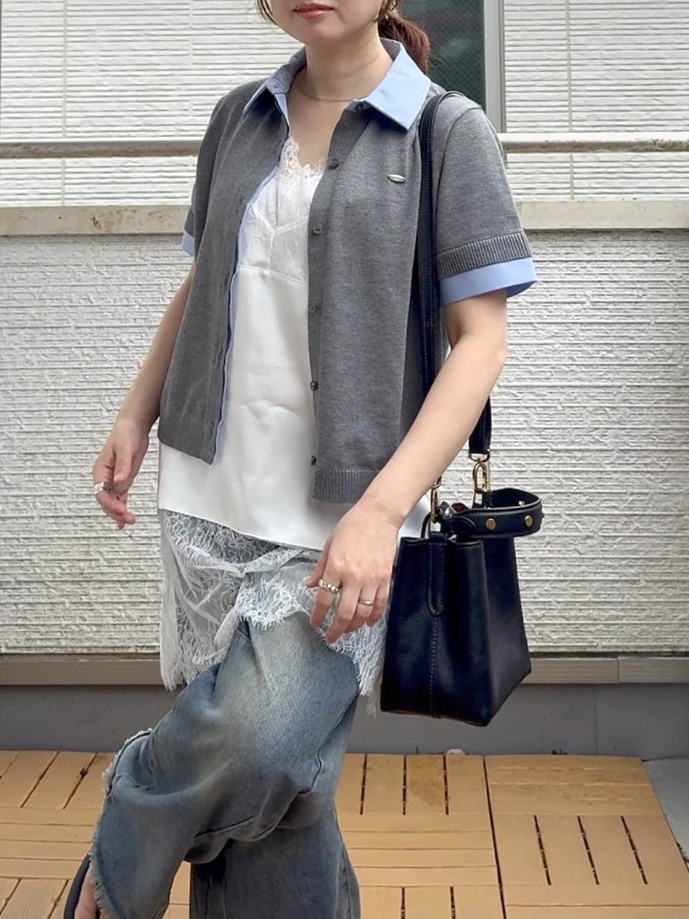ホワイト系のキャミソール、ブルー系のデニムパンツ、グレー系のカーディガン/ボレロを着用したレディースの夏コーディネートの4枚目の写真