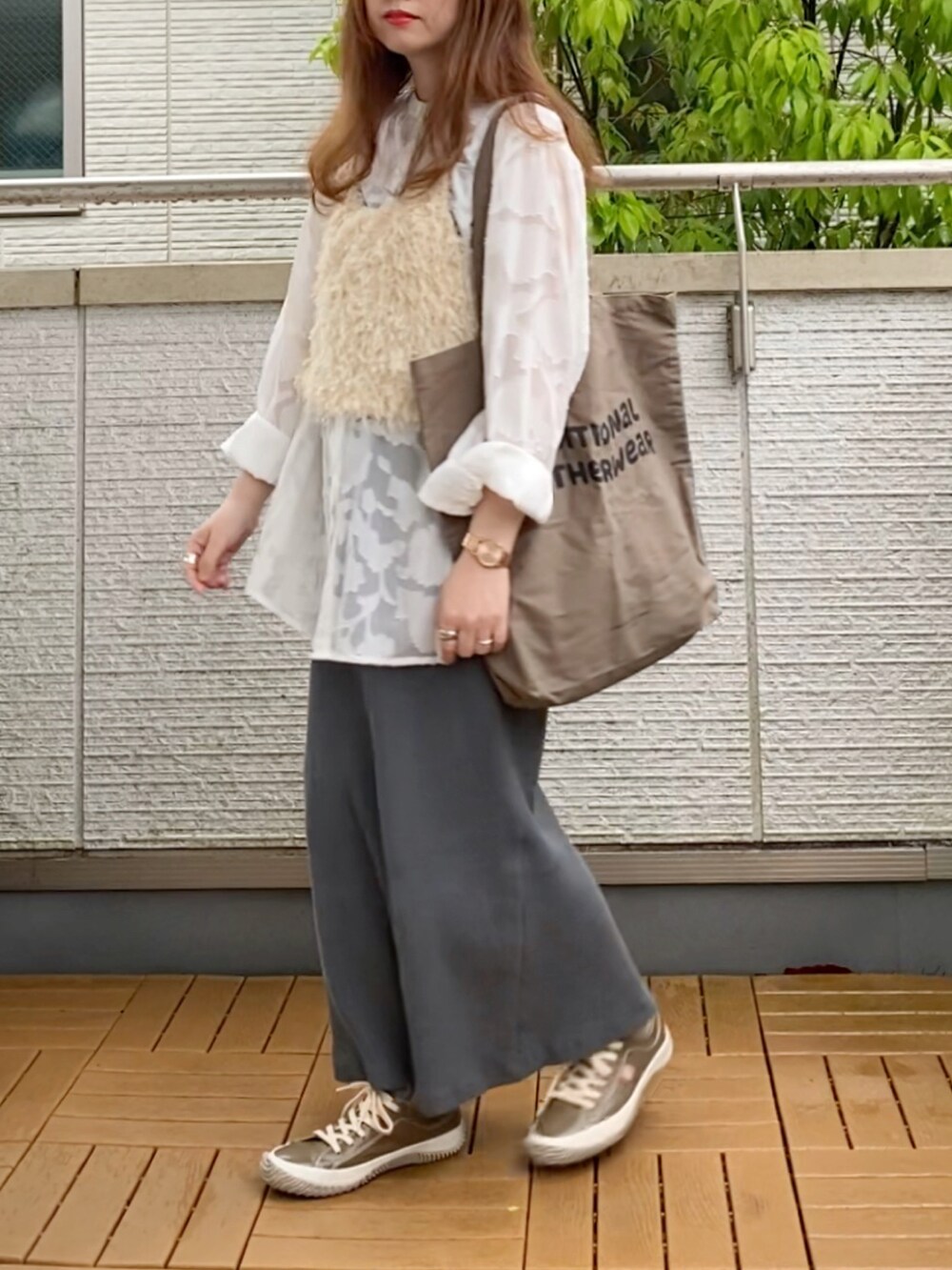 ホワイト系のベスト、ホワイト系のシャツ/ブラウス、グレー系のスカートを着用したレディースの春コーディネートの2枚目の写真