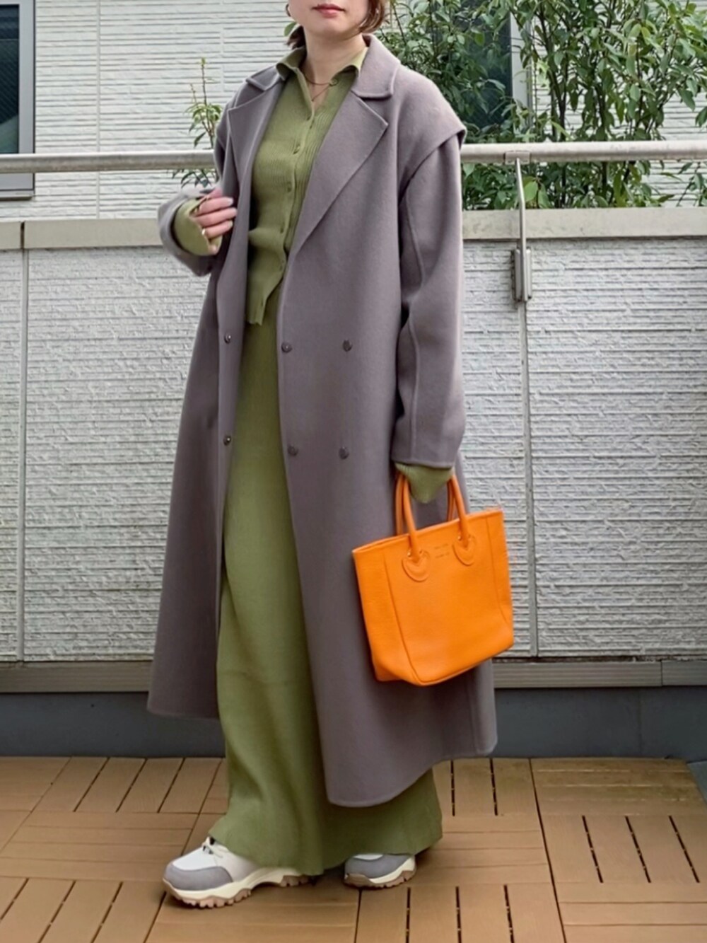 ブラウン系のチェスターコート、グリーン系のカーディガン/ボレロ、グリーン系のスカートを着用したレディースの秋コーディネートの3枚目の写真