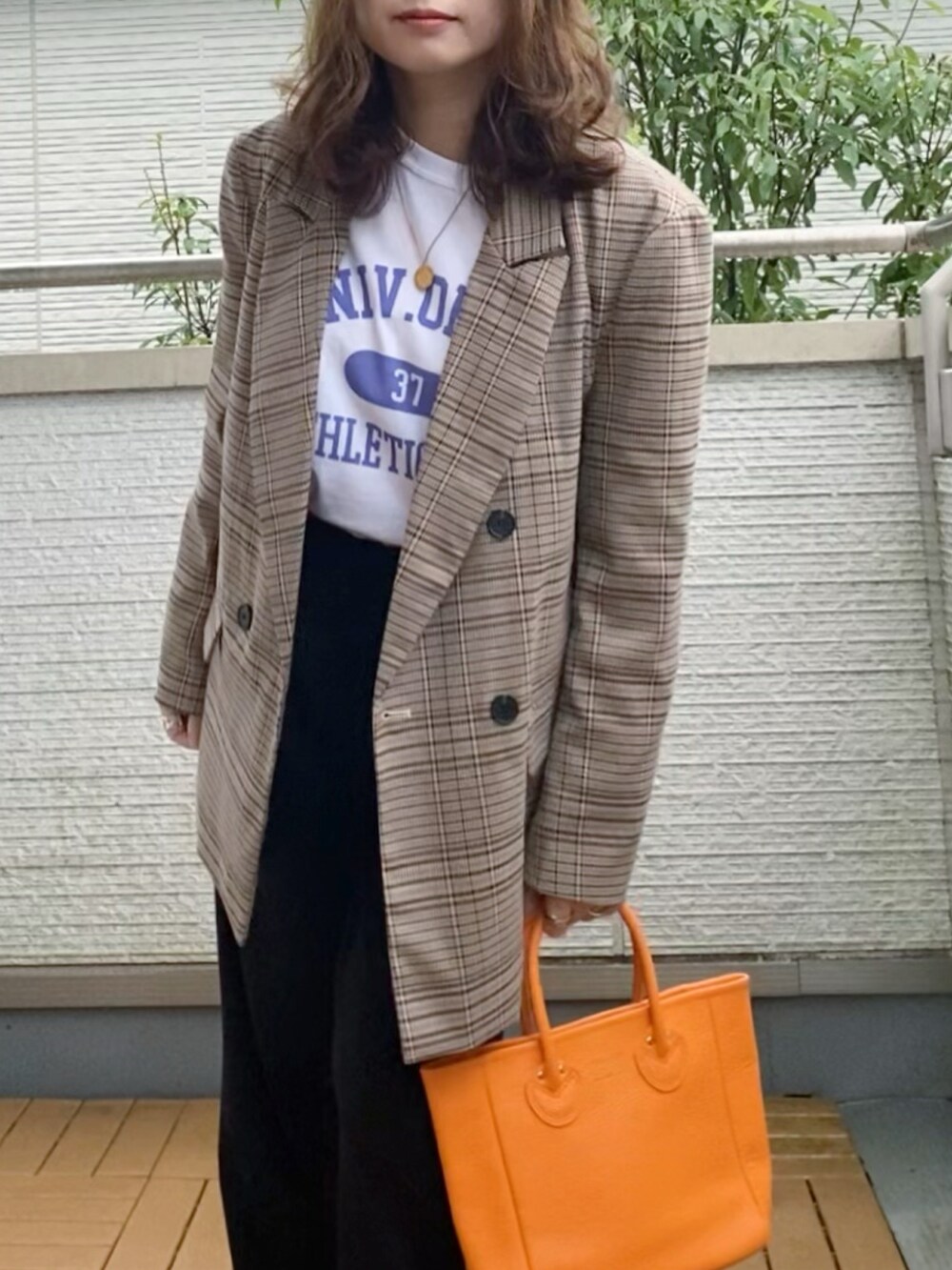 ブラウン系のテーラードジャケット、ホワイト系のTシャツ/カットソー、ブラック系のスラックスを着用したレディースの秋コーディネートの2枚目の写真