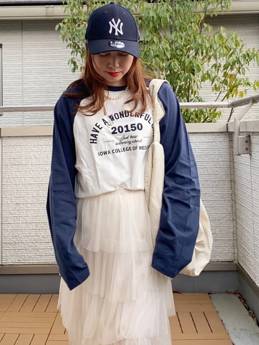 ホワイト系のTシャツ/カットソー、ホワイト系のスカート、ホワイト系のショルダーバッグを着用したレディースの春コーディネートの2枚目の写真