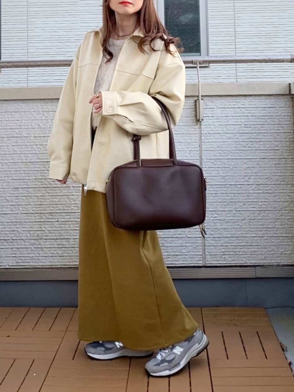 ホワイト系のブルゾン、ホワイト系のニット/セーター、グリーン系のスカートを着用したレディースの冬コーディネートの2枚目の写真