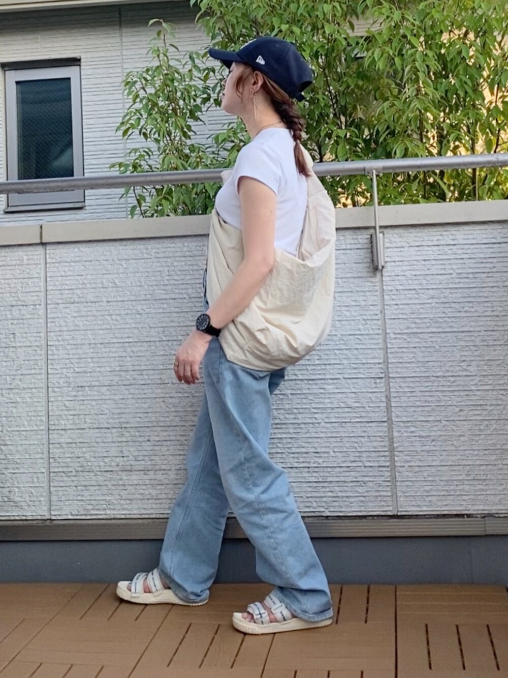 ホワイト系のTシャツ/カットソー、ブルー系のデニムパンツ、ホワイト系のショルダーバッグを着用したレディースの夏コーディネートの2枚目の写真