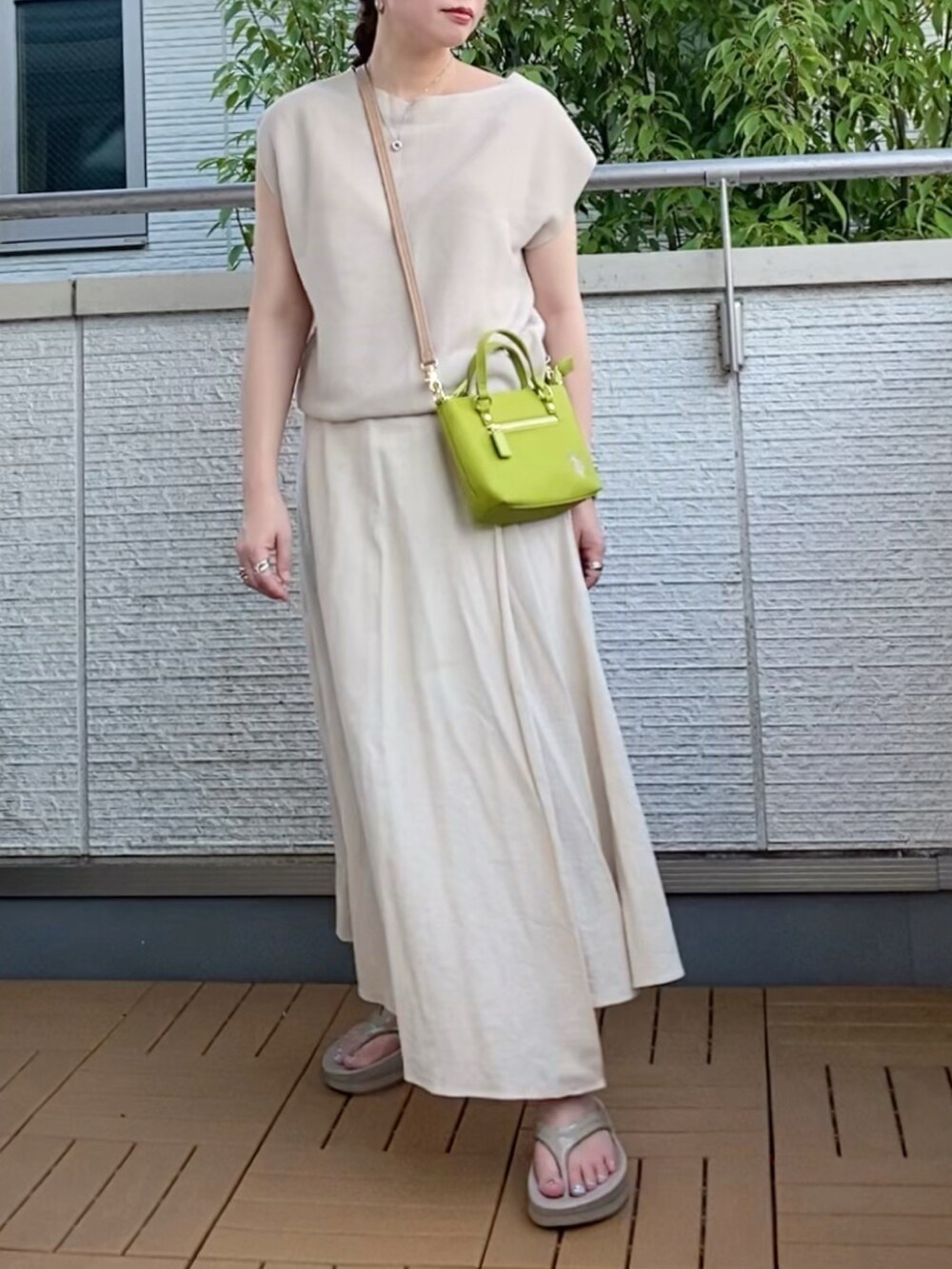 ベージュ系のニット/セーター、ベージュ系のスカート、グリーン系のショルダーバッグを着用したレディースの夏コーディネートの2枚目の写真