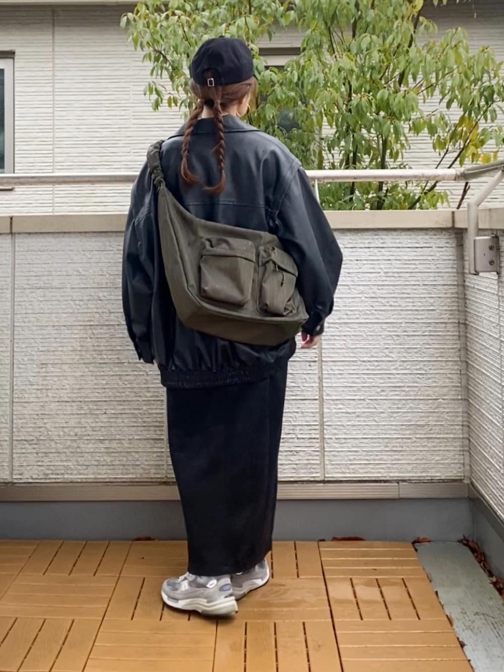 ブラック系のライダースジャケット、ホワイト系のスウェット、ブラック系のスカートを着用したレディースの春コーディネートの3枚目の写真