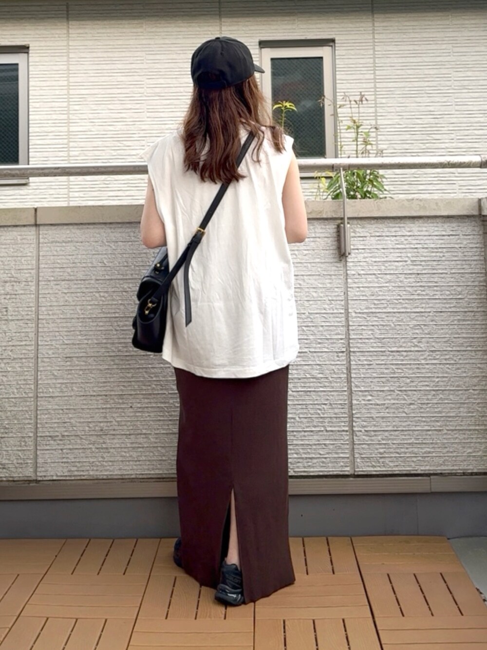 ホワイト系のTシャツ/カットソー、ブラウン系のスカート、ブラック系のハンドバッグを着用したレディースの夏コーディネートの3枚目の写真