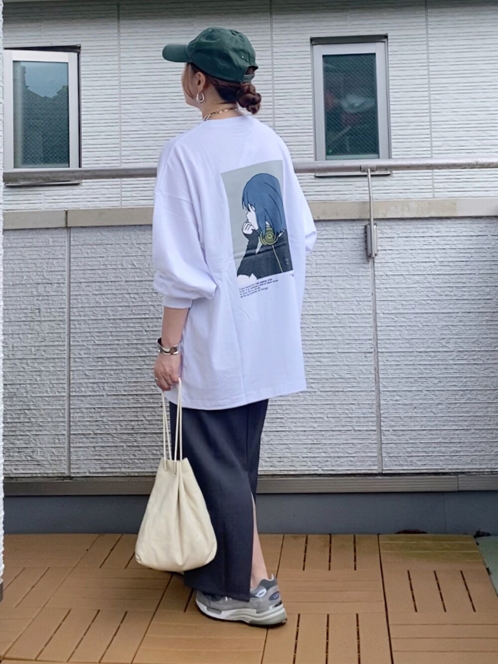 ホワイト系のTシャツ/カットソー、グレー系のスカート、グレー系のスニーカーを着用したレディースの秋コーディネートの2枚目の写真